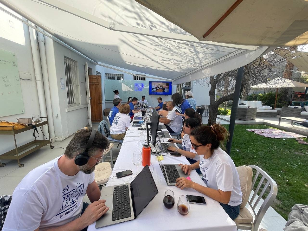 Mesa larga bajo un toldo: el equipo con poleras Decide Chile trabaja en sus computadores durante la jornada.