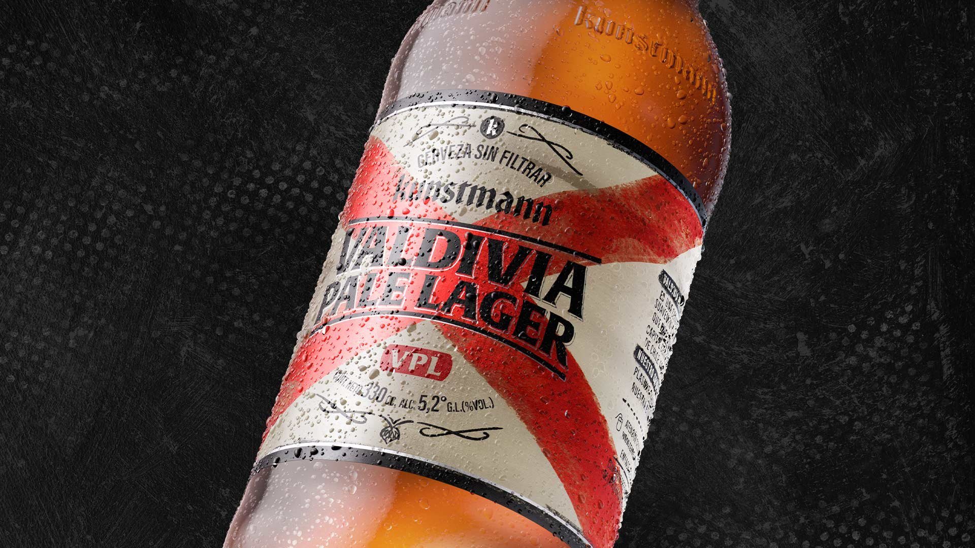 Detalle de la botella Kunstmann VPL, Valdivia Pale Lager, sobre fondo oscuro.