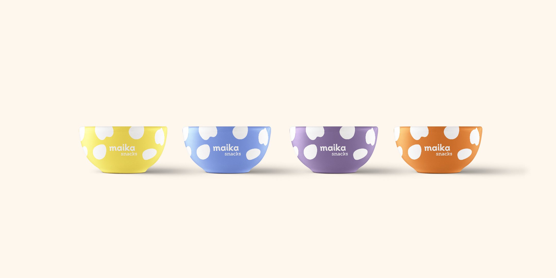 Diseño de cuatro bowls de cerámica de Maika en amarillo, azul, violeta y naranja, con manchas blancas y el logotipo calado.
