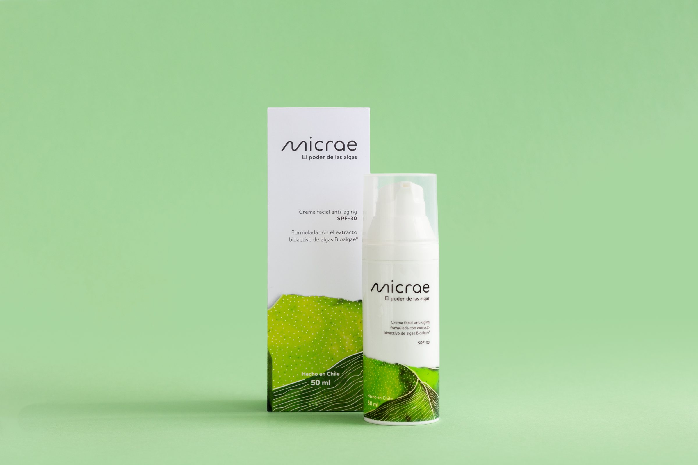 Caja y frasco de la crema facial Micrae sobre fondo verde claro.